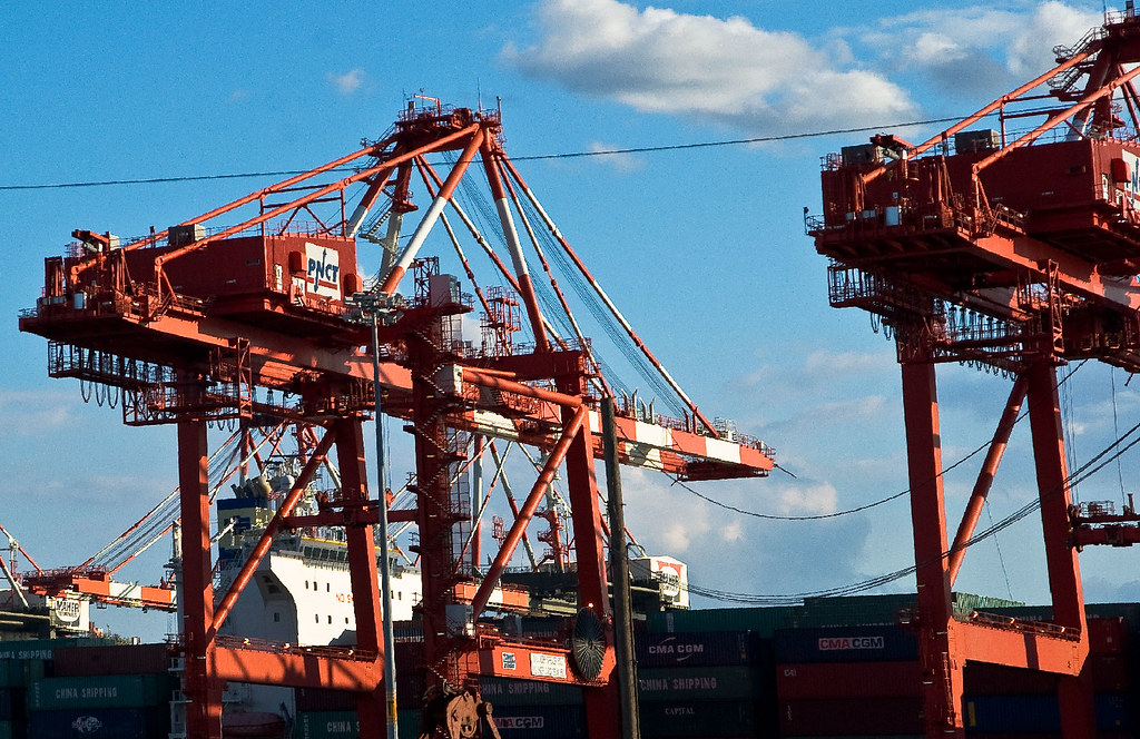 Container ship at port with gantry cranes loading cargo